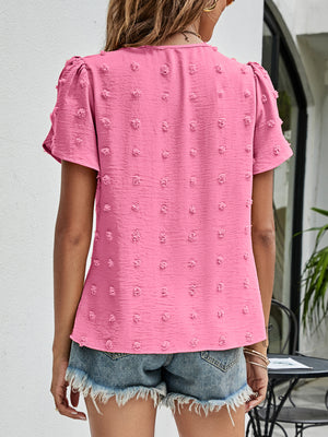 Pink textured puff sleeve blouse with dot pattern and short sleeves.