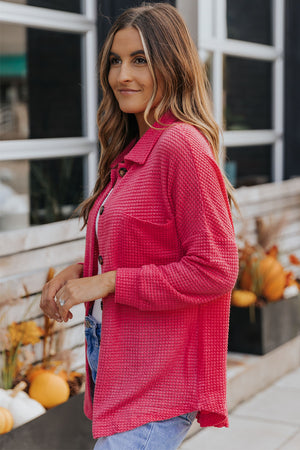 Waffle-knit oversized shirt jacket in strawberry pink with button front and chest pocket.