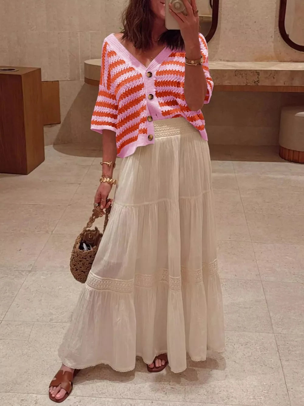 Pink and orange striped knit cardigan with buttons, V-neck, and short sleeves.