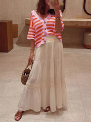 Pink and orange striped knit cardigan with buttons, V-neck, and short sleeves.