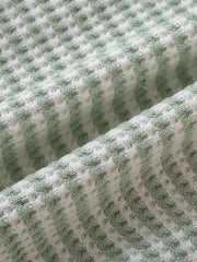 Light green and white striped baby knit set fabric detail.