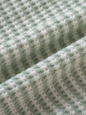 Light green and white striped baby knit set fabric detail.