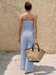 Blue striped strapless maternity romper with smocked waist and wide legs.