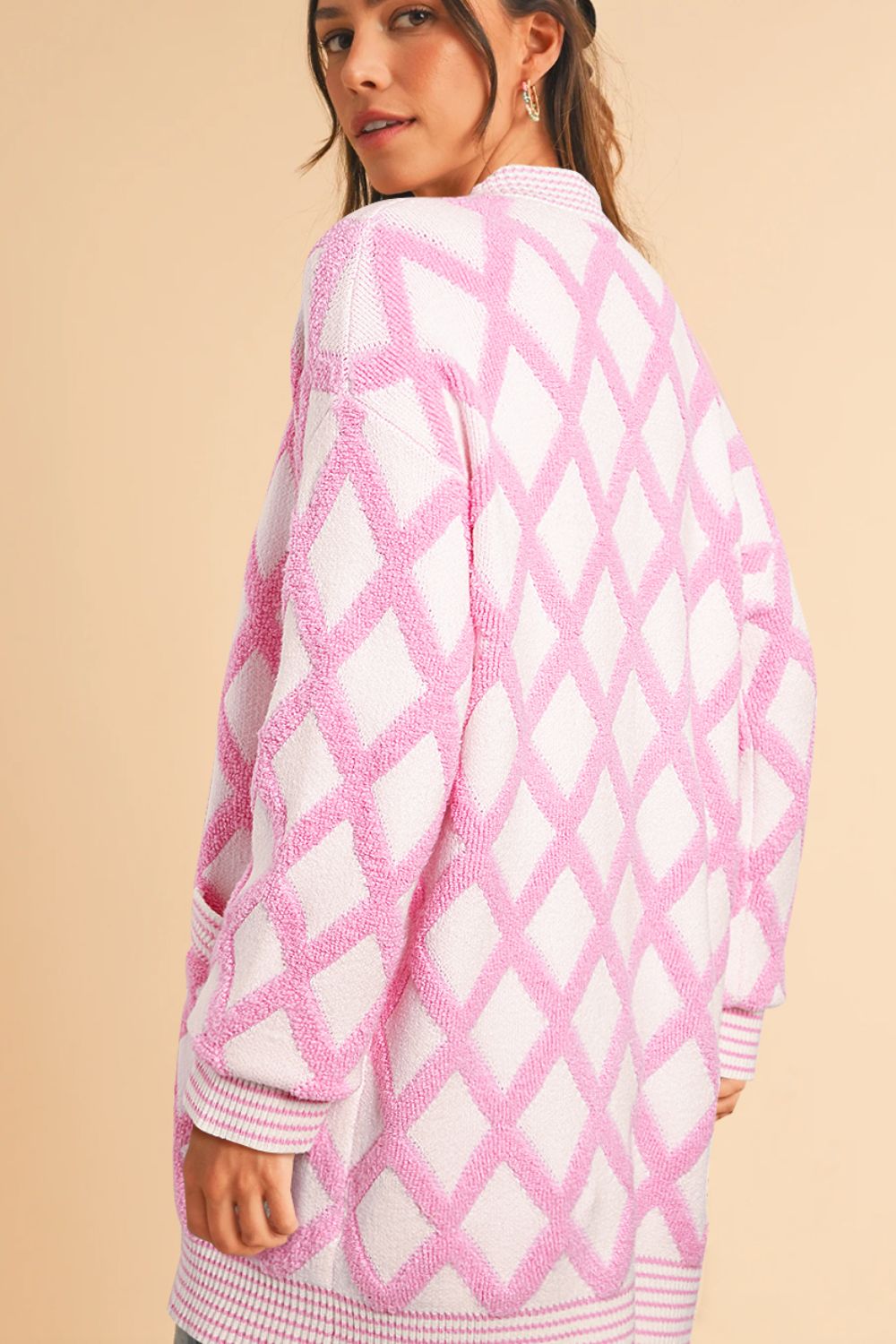 Diamond jacquard knit open cardigan in blush pink with textured diamond pattern and ribbed trim.