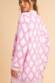 Diamond jacquard knit open cardigan in blush pink with textured diamond pattern and ribbed trim.