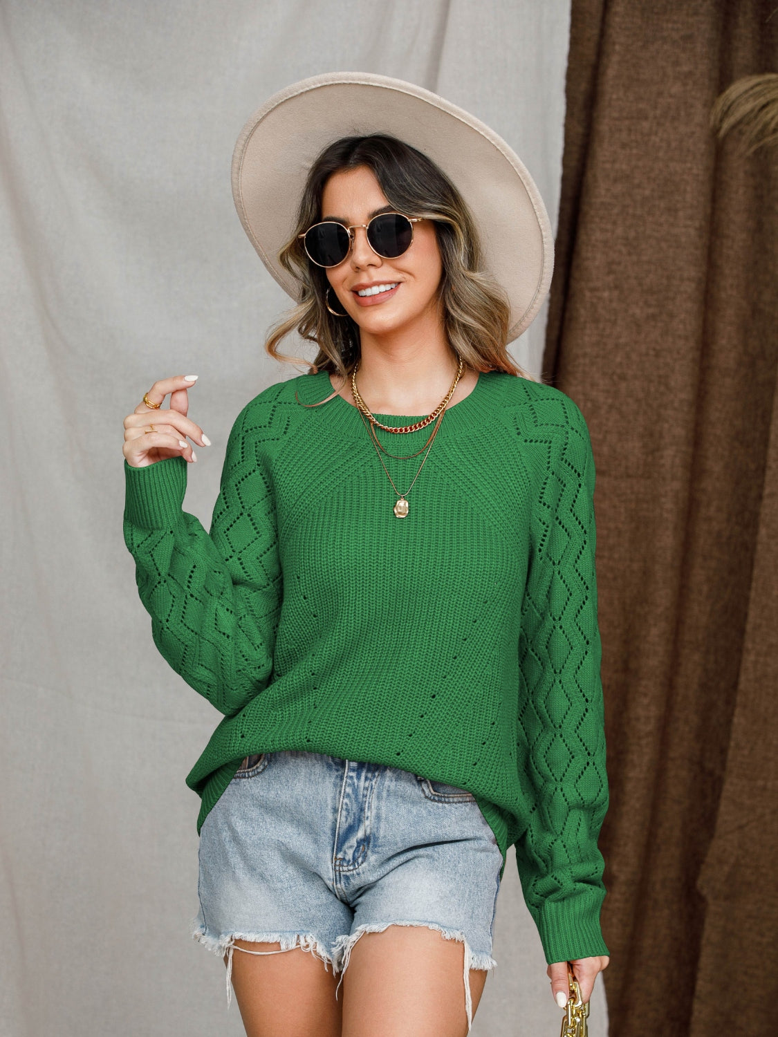 Green diamond-cut raglan knit sweater with crew neck and long sleeves.