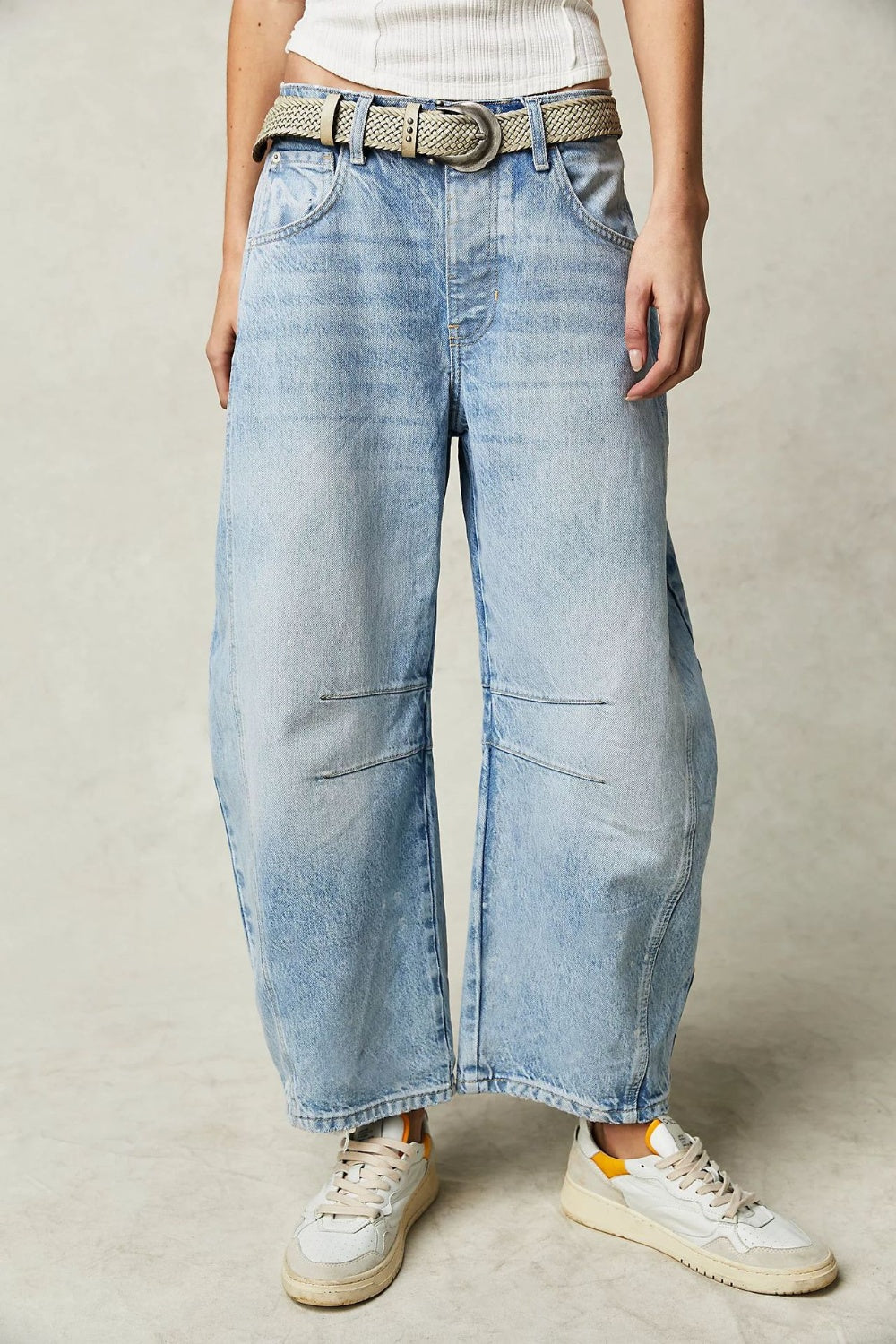 Light blue denim barrel leg jeans with knee panel detail and a woven belt.