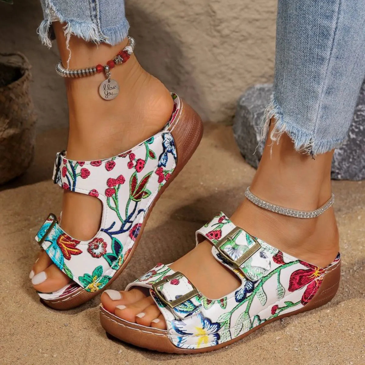 Floral double-strap buckle slides with adjustable straps and contoured footbed.