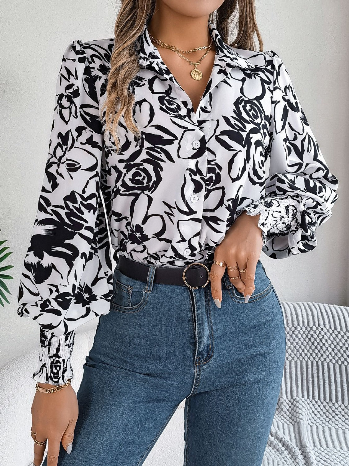 White floral print blouse with shirred cuffs and buttoned front.