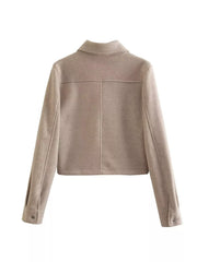 Beige trucker jacket with collared neckline, long sleeves, and button cuffs.