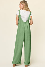 Light Green ribbed knit tie-strap jumpsuit with wide legs and a white t-shirt underneath.