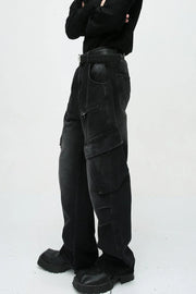 Baggy black denim cargo pants with zipper pockets and large flap pockets.