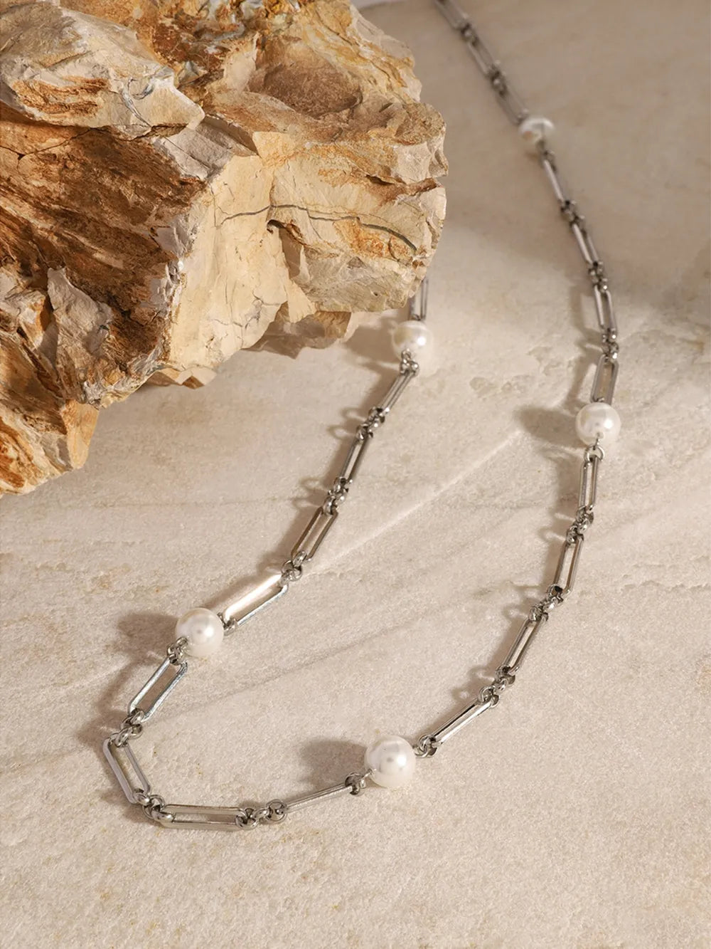 Silver two-tone pearl link necklace with elongated chain links and round pearls.