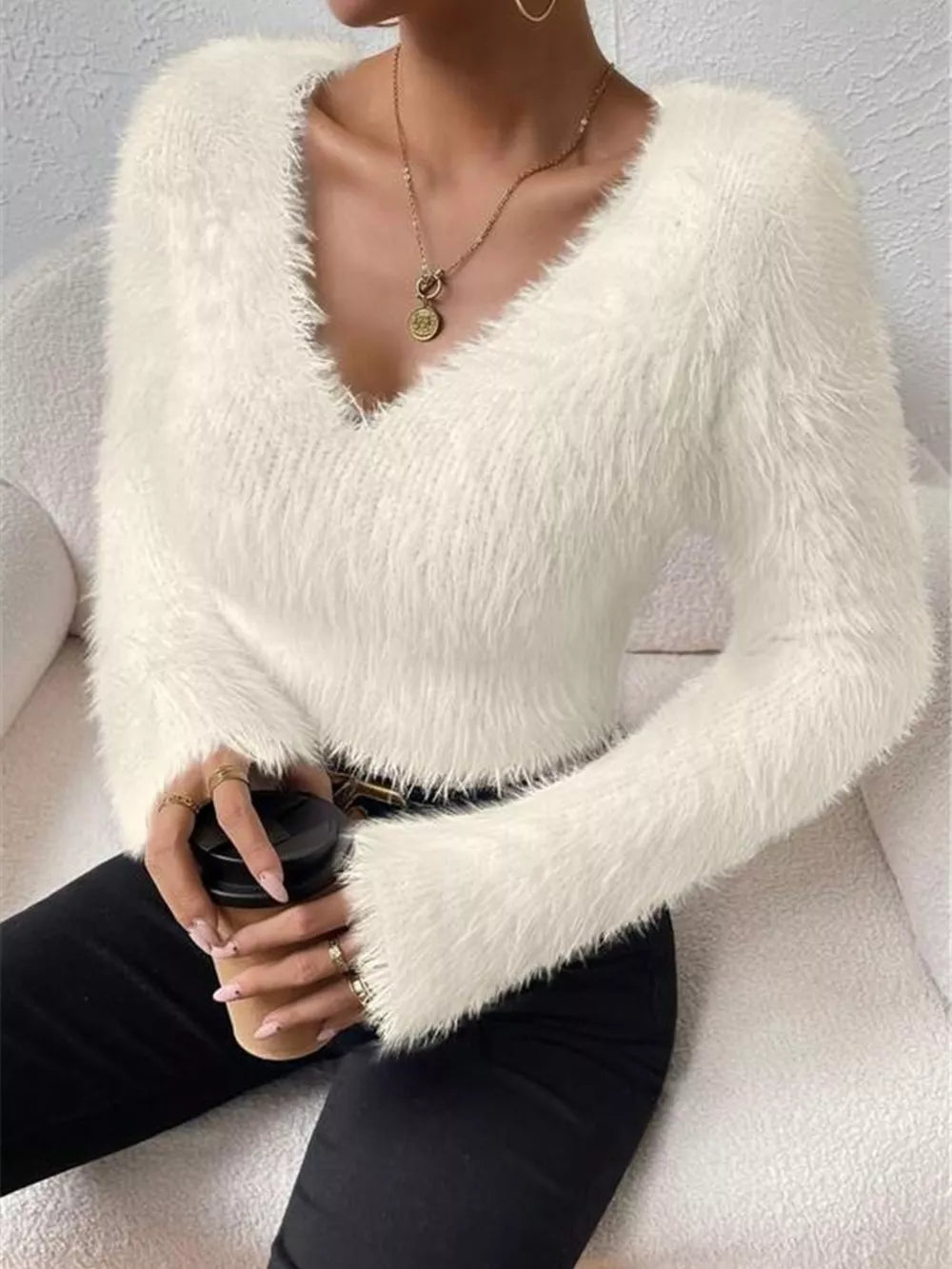 White fluffy V-neck knit sweater with long sleeves and a cozy texture.