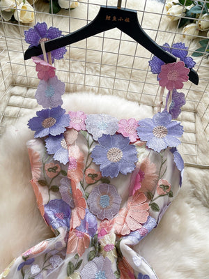 Embroidered floral mini dress with 3D flowers on straps and neckline in pastel colors.