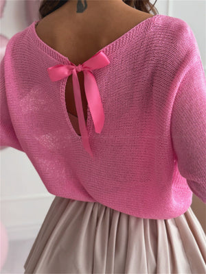 Fuchsia pink knit sweater with batwing sleeves and a bow-back detail.