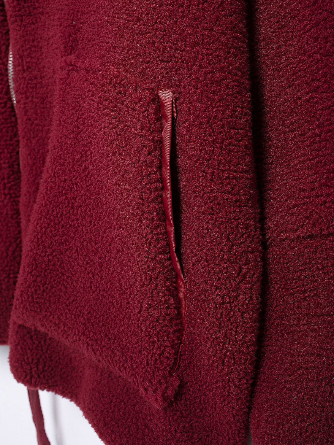 Burgundy sherpa jacket with a visible pocket detail and zipper.
