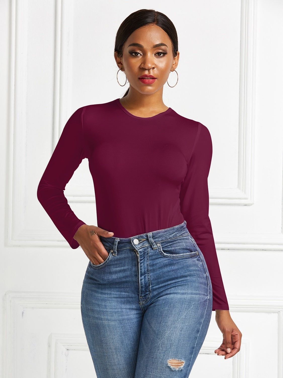Burgundy ribbed jersey bodysuit with long sleeves and crew neck, styled with jeans.