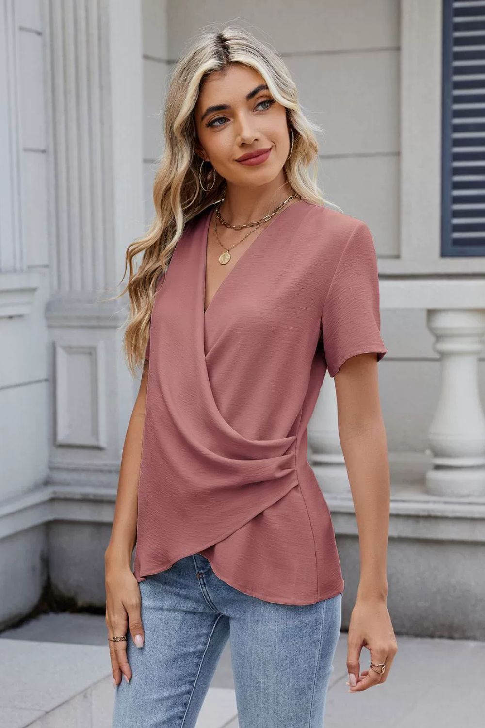 Dusty pink short sleeve blouse with draped crossover front and ruched side detail.