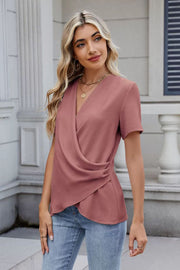 Dusty pink short sleeve blouse with draped crossover front and ruched side detail.