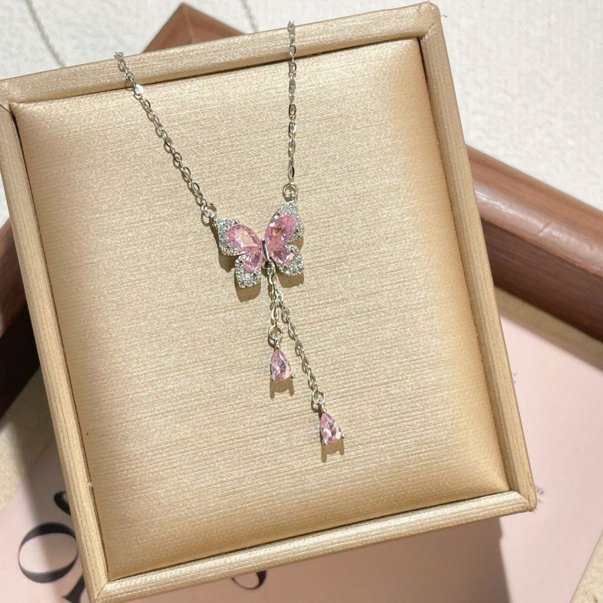 Sparkling butterfly pendant necklace with pink gems and delicate chain.