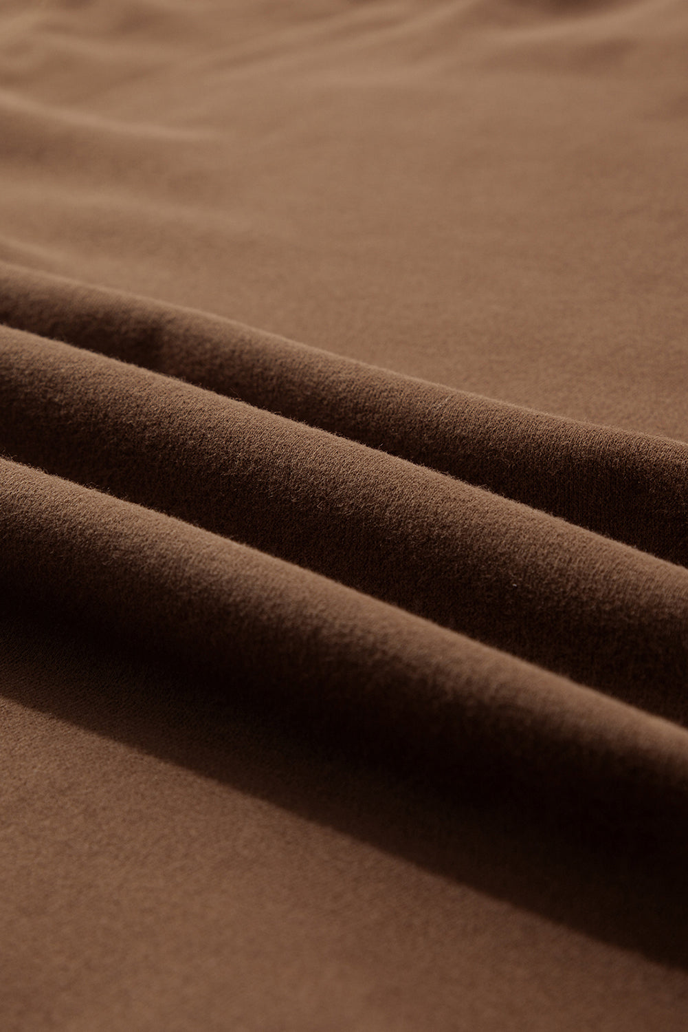 Coffee brown relaxed fit lounge set fabric detail with soft texture and draped folds.
