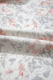 Floral print wide-leg jeans in cotton with pink and grey floral pattern on white.