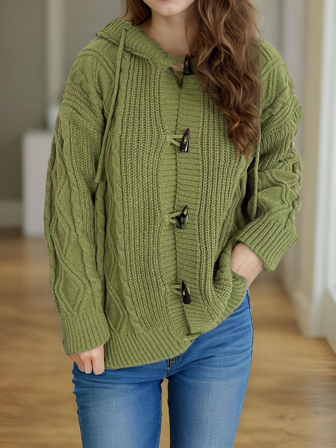 Moss green cable knit hoodie with toggle buttons and a hood.