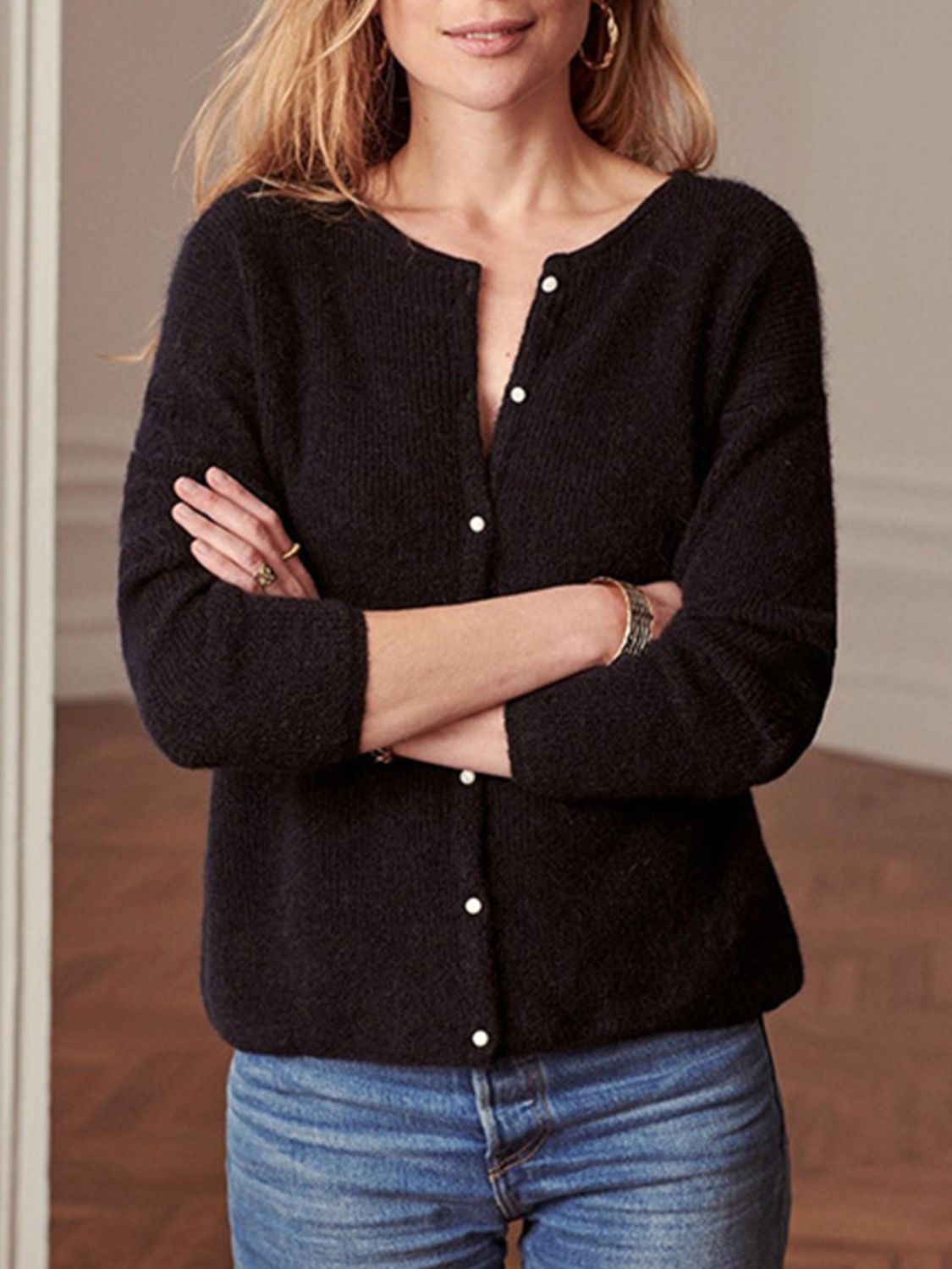 Black cashmere button cardigan with a round neckline and three-quarter sleeves.