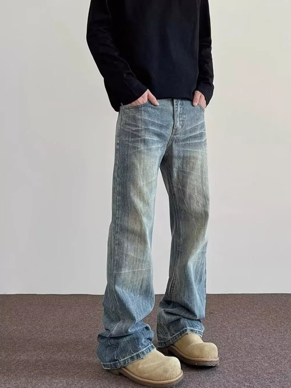 Men's vintage wash blue cotton wide leg jeans with distressed details.
