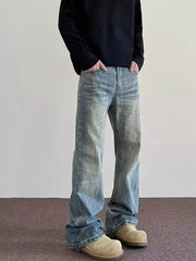 Men's vintage wash blue cotton wide leg jeans with distressed details.