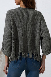 Distressed knit sweater in dark gray with frayed hem and sleeves.