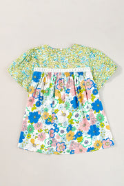 Floral patchwork puff sleeve blouse with smocked detail and white lace trim.