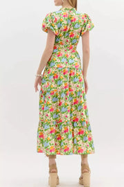 Vibrant floral maxi dress with ruffled neckline, smocked waist, tiered skirt, and puff sleeves.