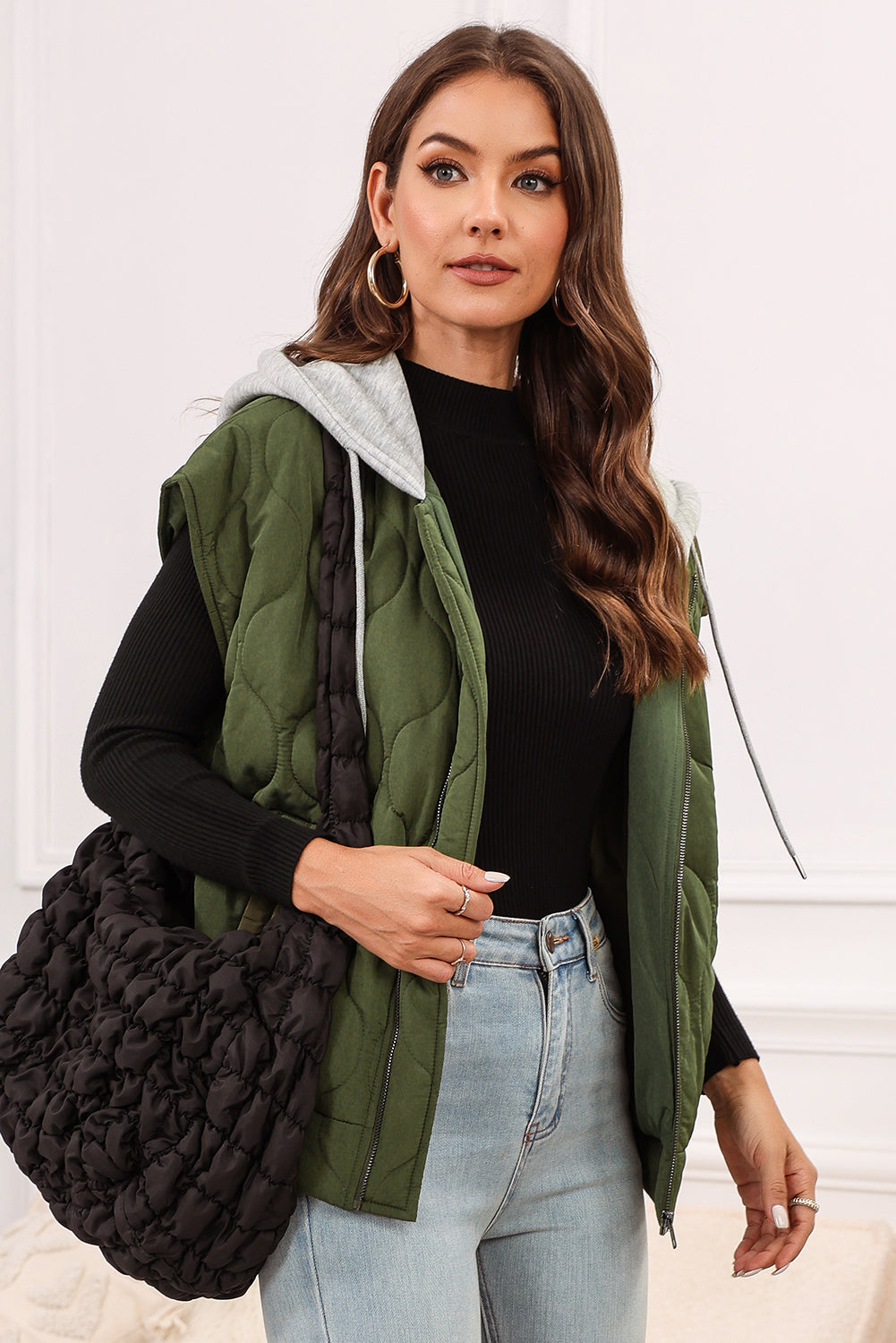 Moss quilted hooded sleeveless jacket with a grey hood and black trim.