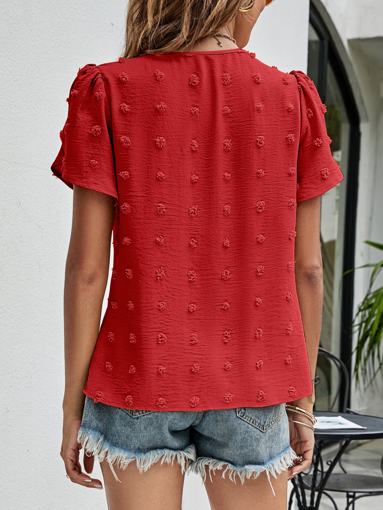 Red textured puff sleeve blouse with dot pattern and short sleeves.