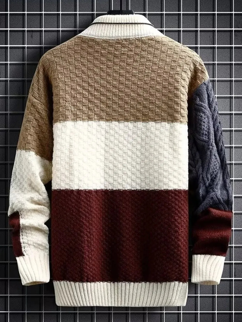 Men's color block cable-knit pullover sweater with textured panels and ribbed collar.