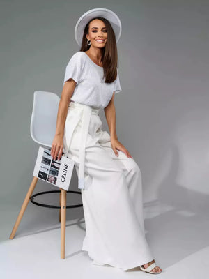 White wide-leg jumpsuit with tie waist and shimmering sequin top.