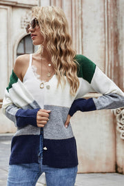 Colorblock acrylic cardigan with white, grey, navy, and green stripes and metallic trim.