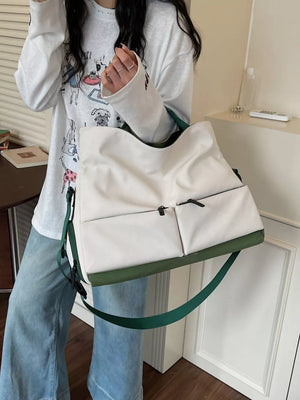 Premium Oxford cloth travel bag in ivory with green trim and strap, featuring two front zip pockets.