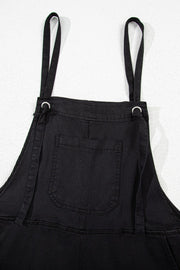 Black denim romper with adjustable straps and a front pocket.