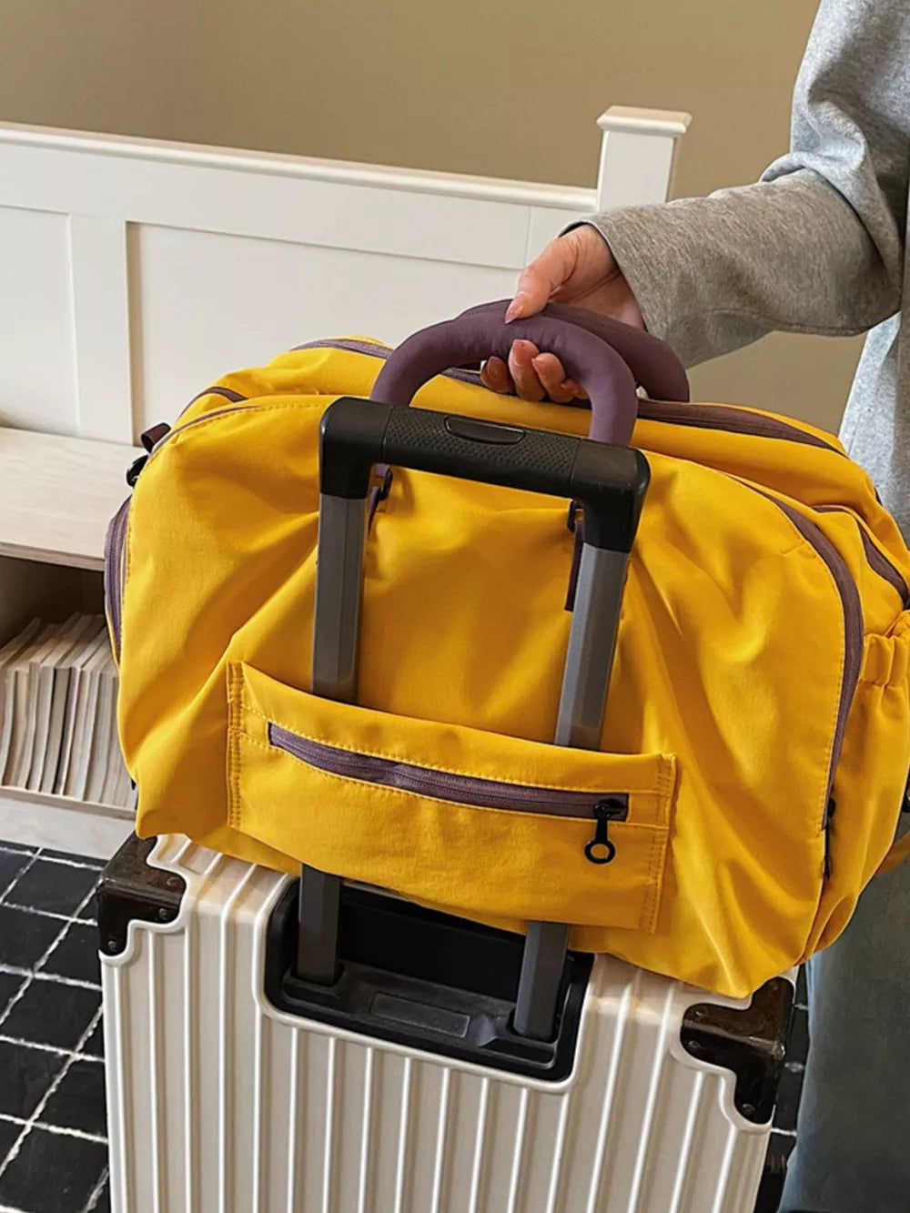 Yellow travel organizer bag with purple accents and a front zipper pocket.