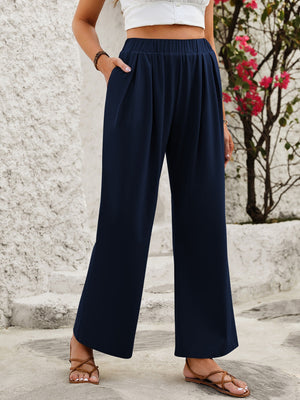 Navy wide leg trousers with elastic waist and pockets, styled with sandals.