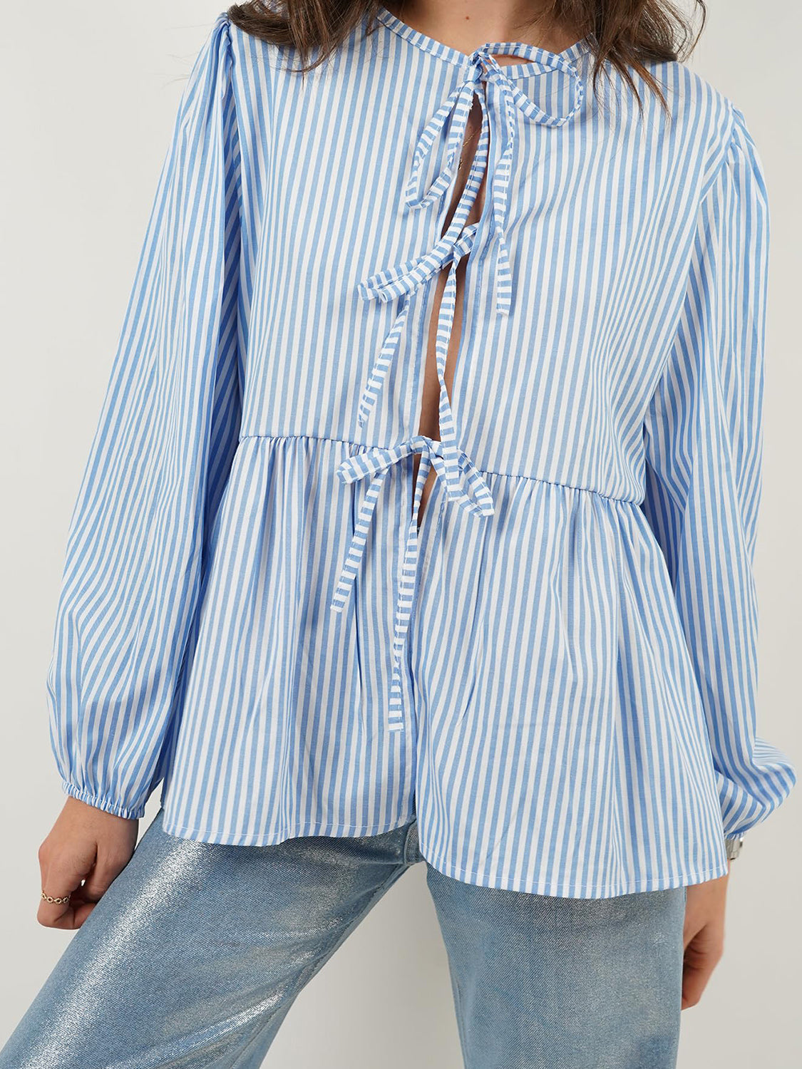 Blue and white striped peplum blouse with voluminous sleeves and tie front detail