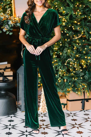 Dark green velvet wrap bodice jumpsuit with short sleeves and wide legs, cinched waist.