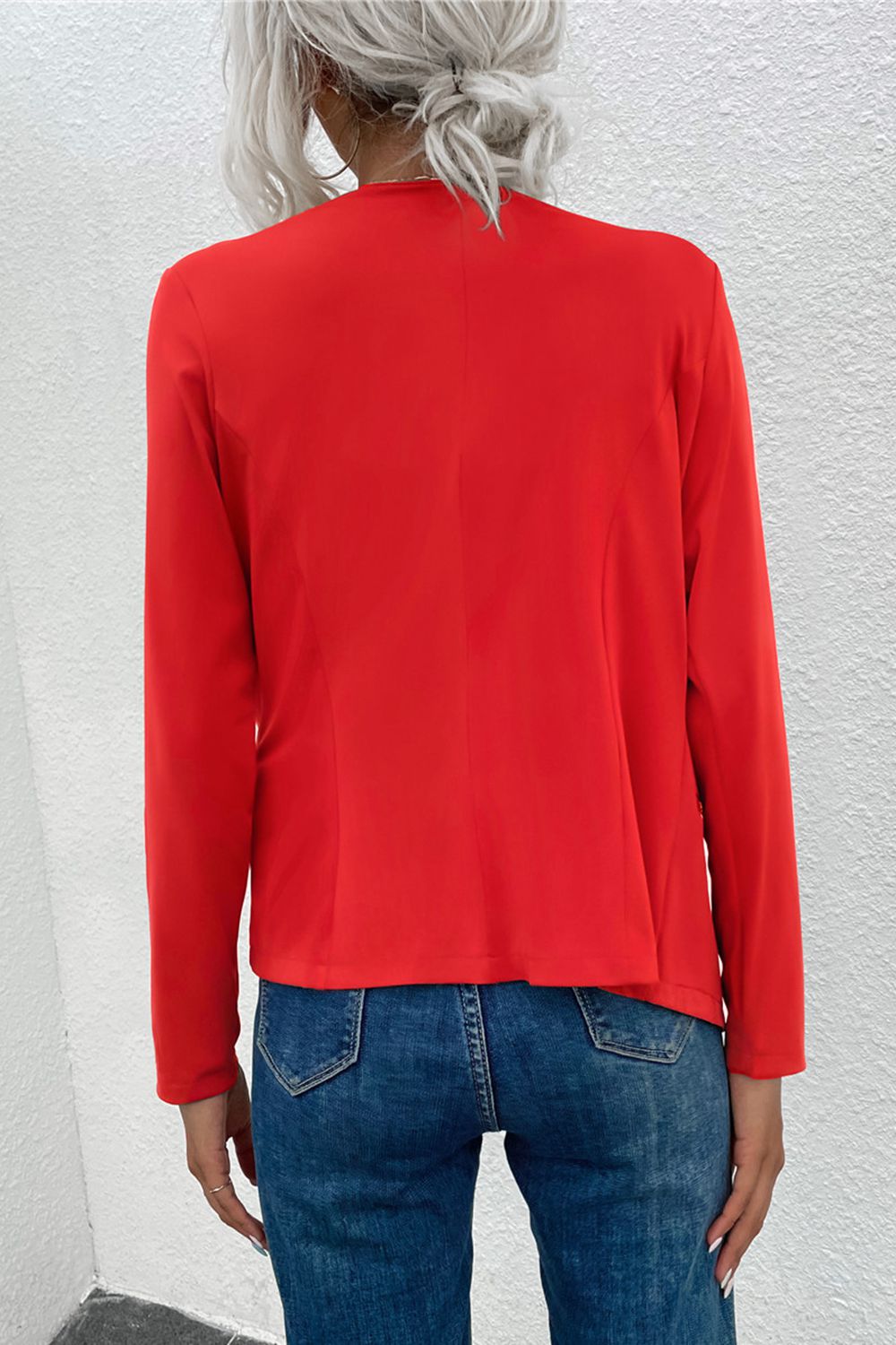 Red drape front jacket with zip detail and long sleeves, styled with jeans.
