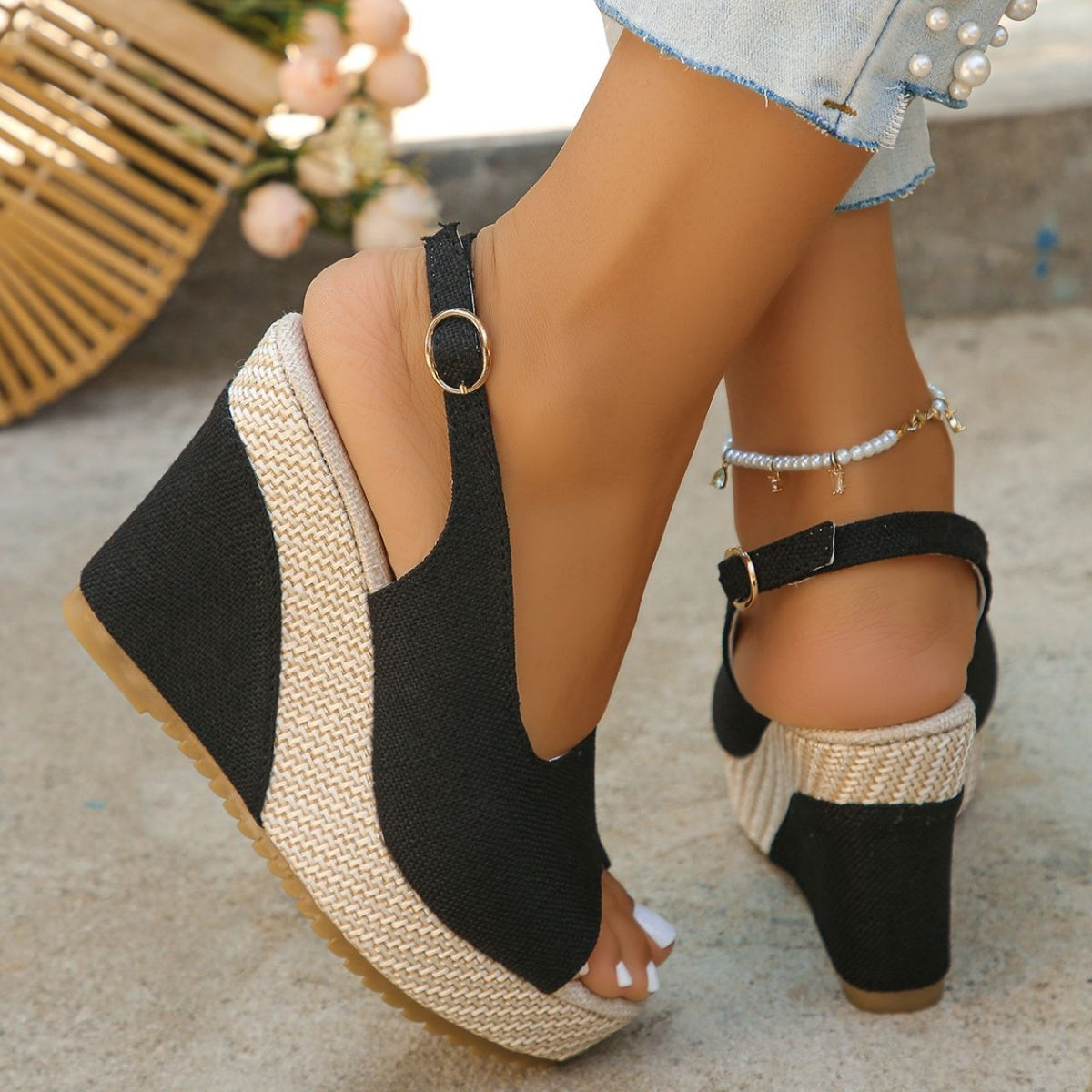 Black woven espadrille wedge sandals with ankle strap and peep toe detail.