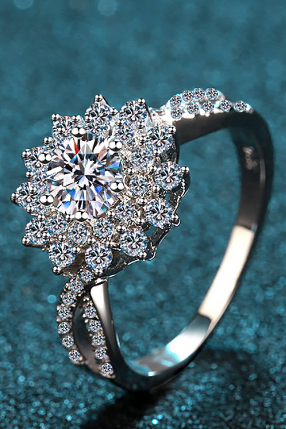 Silver ring with a large round moissanite center stone surrounded by a halo of smaller stones.