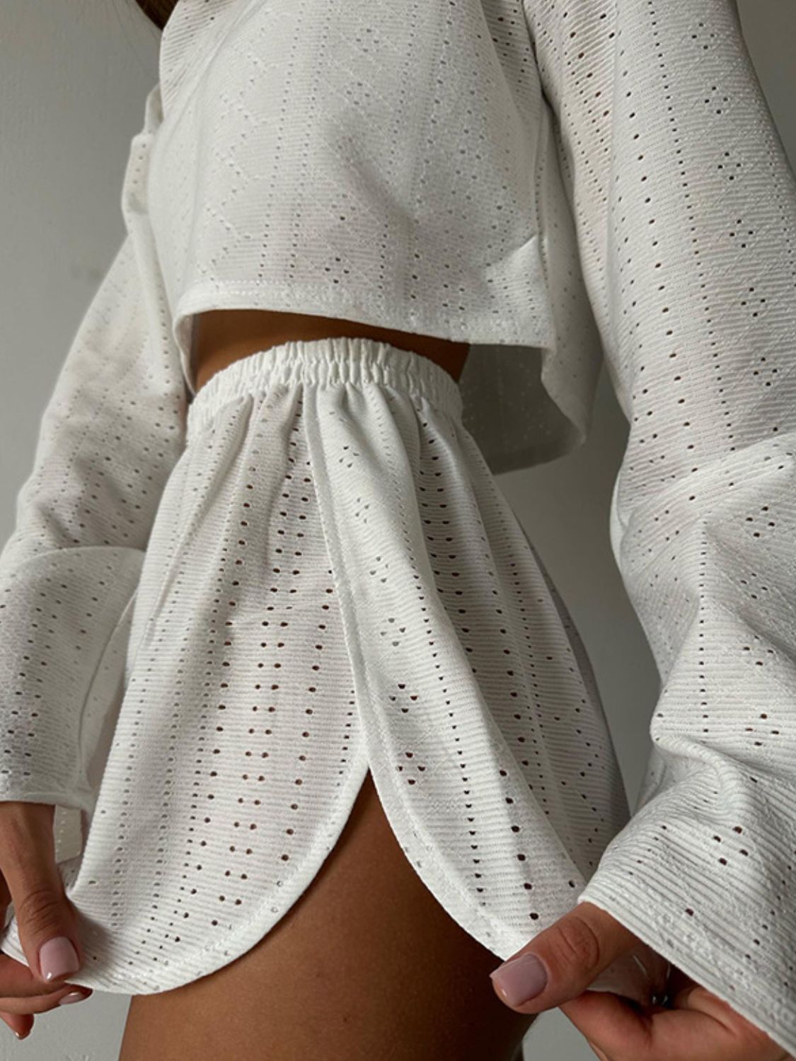 White perforated crop top and shorts set with elastic waist shorts and bell sleeves.
