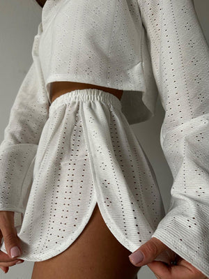 White perforated crop top and shorts set with elastic waist shorts and bell sleeves.
